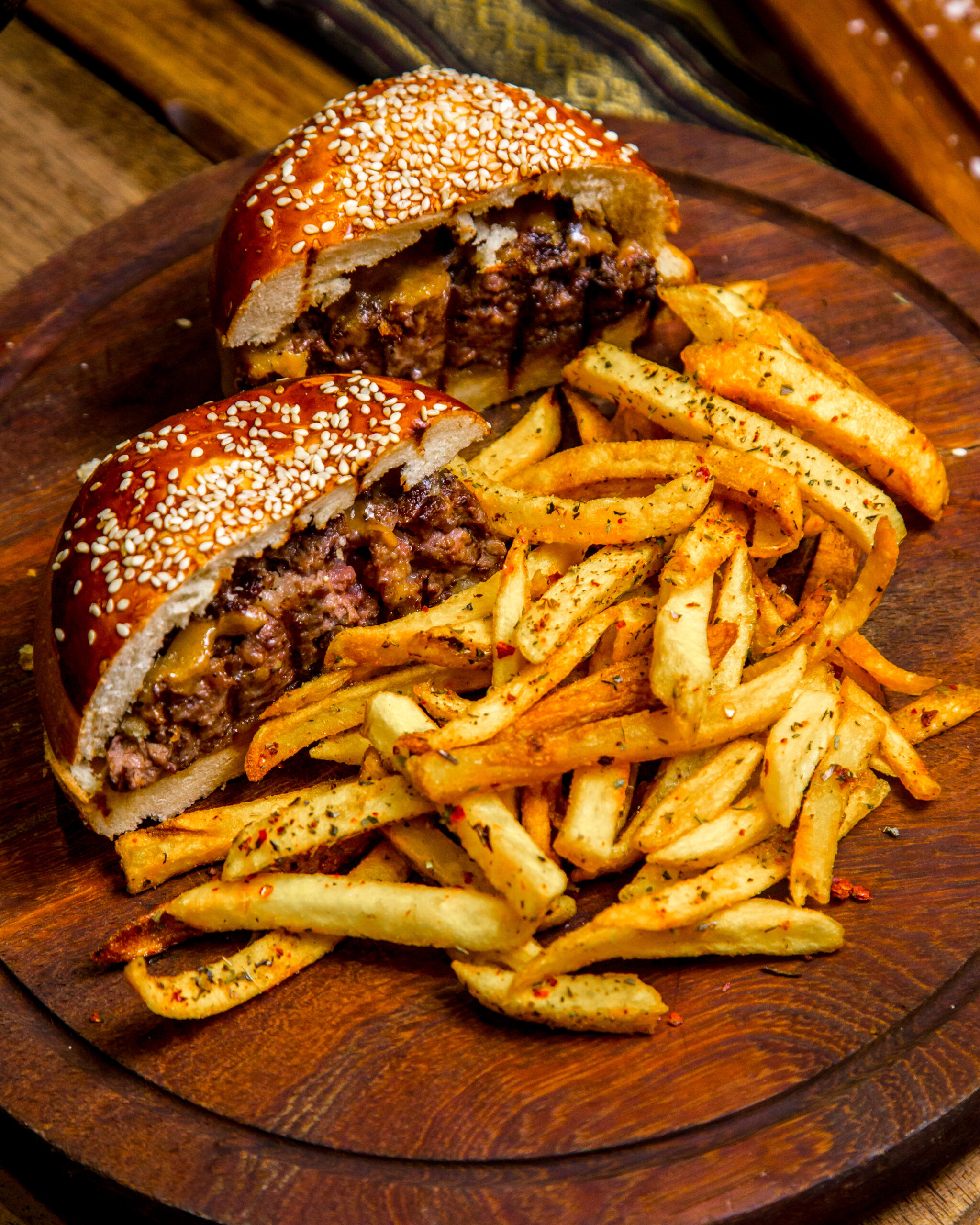 meat burger on wooden board french fries side view